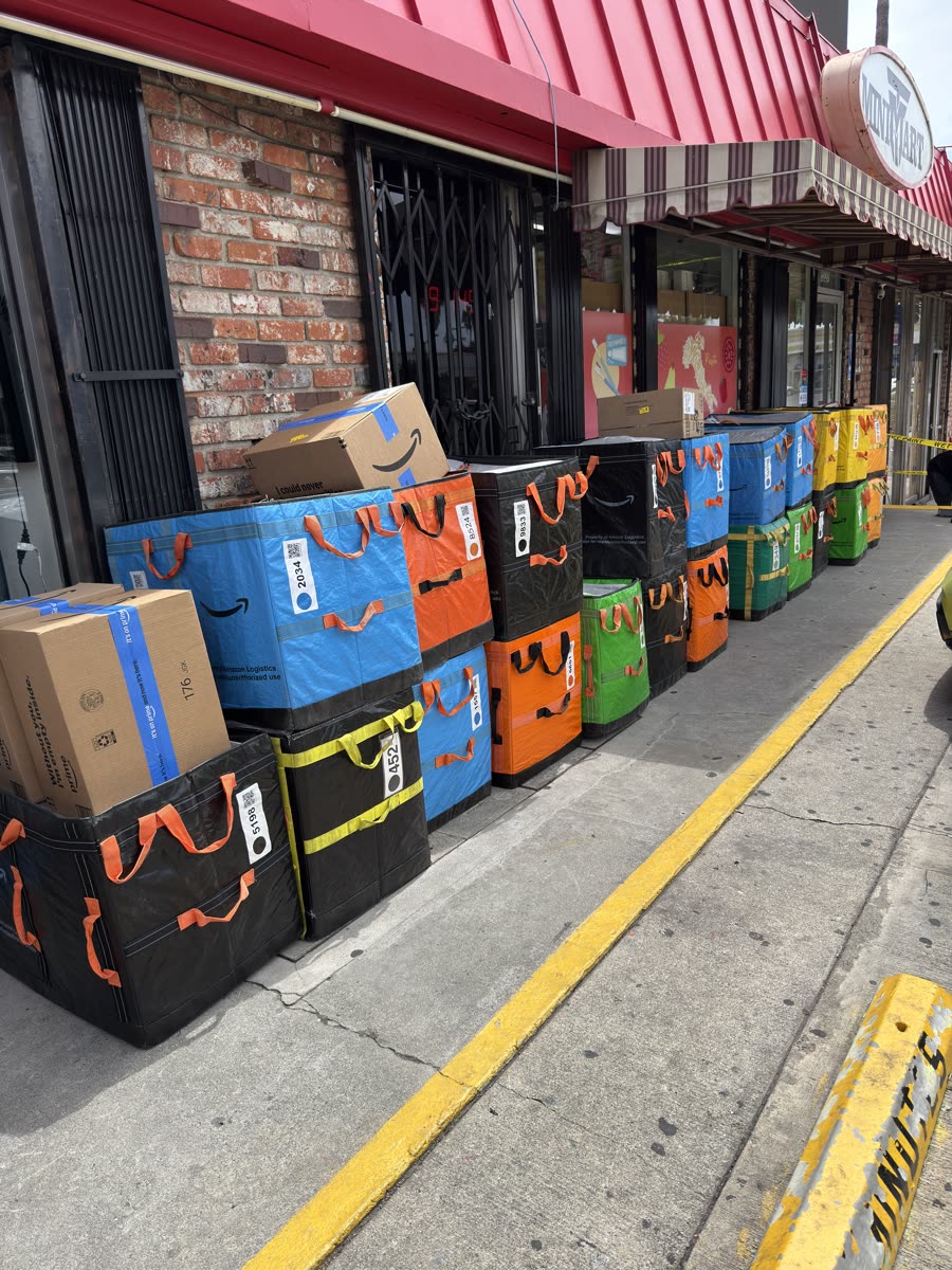 Large line of Amazon Hub containers staged outside a Los Angeles business