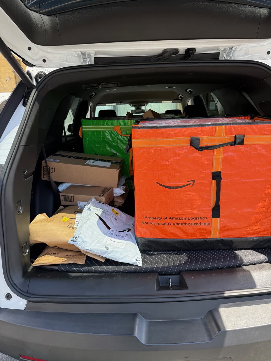 Orange Amazon Hub container and parcels inside a delivery vehicle